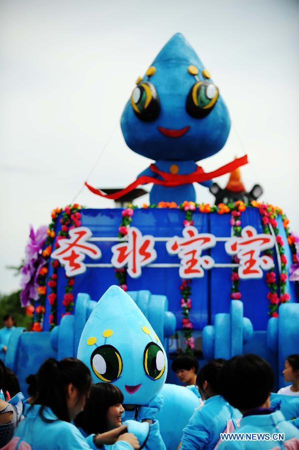 The water mascot of the traditional "Holy Water Festival" prepares to attend the cruise in Wudalianchi, northeast China's Heilongjiang Province, June 11, 2013. The festival was listed as the National Intangible Cultural Heritage in 2010. (Xinhua/Wang Jianwei) 