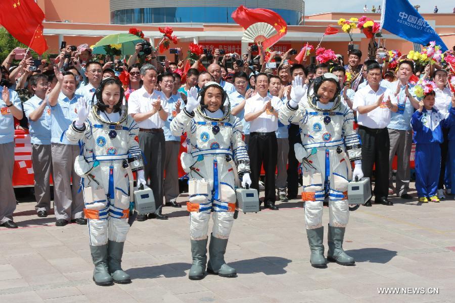 Astronauts Nie Haisheng (R), Zhang Xiaoguang (C) and Wang Yaping wave to people during the setting-out ceremony of the manned Shenzhou-10 mission at the Jiuquan Satellite Launch Center in Jiuquan, northwest China's Gansu Province, June 11, 2013. (Xinhua/Li Peibin)