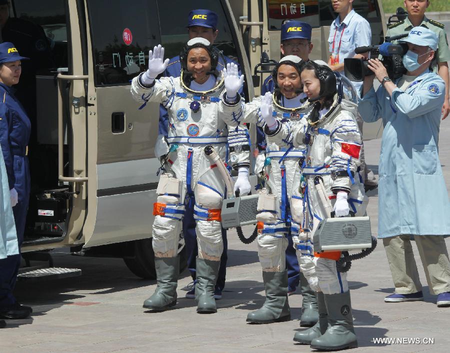 Astronauts Nie Haisheng (L), Zhang Xiaoguang (C) and Wang Yaping prepare to board the bus for the launch center in Jiuquan, northwest China's Gansu Province, June 11, 2013. (Xinhua/Li Gang)