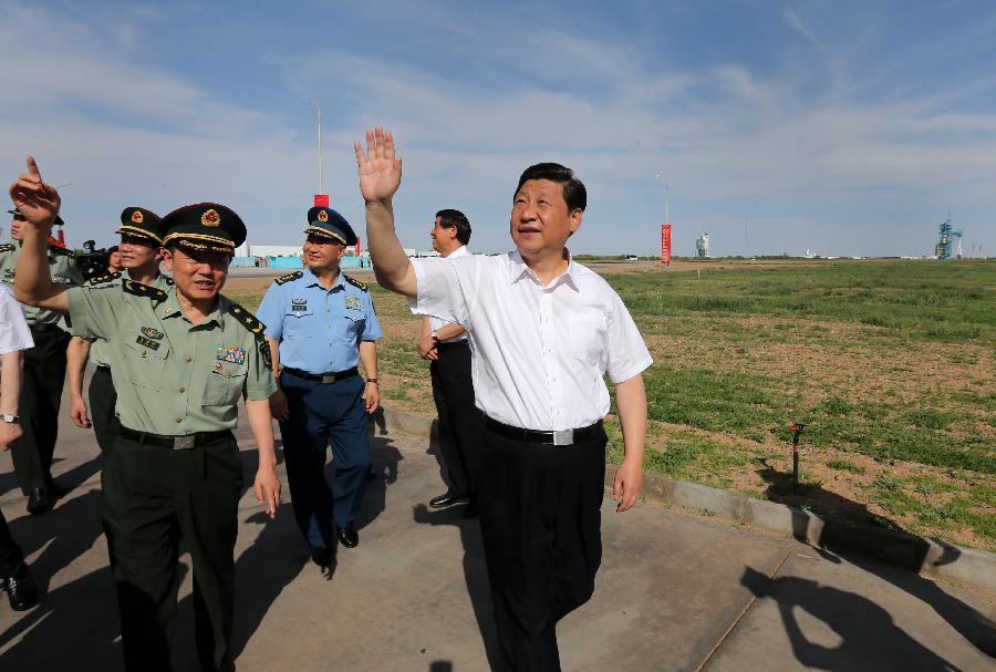 Chinese President Xi Jinping (R, front ), also general secretary of the Central Committee of the Communist Party of China (CPC) and chairman of the Central Military Commission (CMC), waves to journalists and staff members at the Jiuquan Satellite Launch Center in Jiuquan, northwest China's Gansu Province, June 11, 2013. Xi watched conditions of the spacecraft through images and parameters on the screen at the command hall in Jiuquan. (Xinhua/Pang Xinglei)
