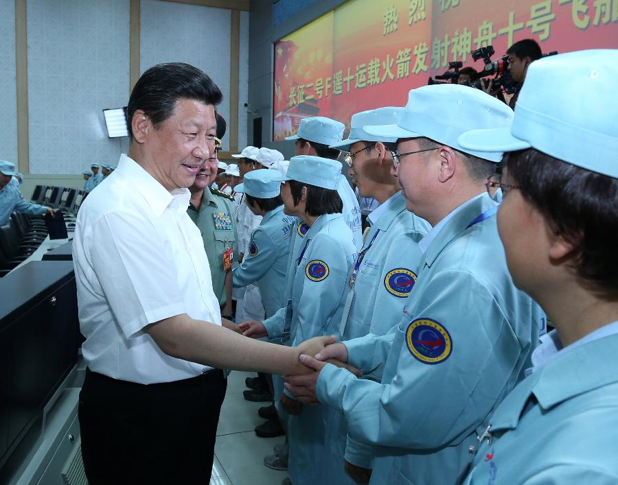 Chinese President Xi Jinping (L), also general secretary of the Central Committee of the Communist Party of China (CPC) and chairman of the Central Military Commission (CMC), shakes hands with those participating in the program of Shenzhou-10 manned spacecraft and sends his warm greetings to them at the Jiuquan Satellite Launch Center in Jiuquan, northwest China's Gansu Province, June 11, 2013. Xi watched conditions of the spacecraft through images and parameters on the screen at the command hall. (Xinhua/Pang Xinglei)