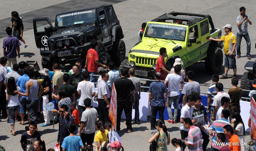Visitors look at Jeep off-road vehicles displayed at the 2013 Central China International Auto Expo in Zhengzhou, capital of central China's Henan Province, June 12, 2013. The five-day expo kicked off here on Wednesday. (Xinhua/Li Bo) 