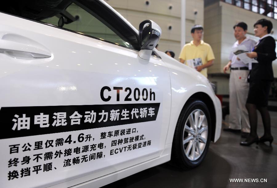 Visitors inquire on the price of Lexus CT200h at the 2013 Central China International Auto Expo in Zhengzhou, capital of central China's Henan Province, June 12, 2013. The five-day expo kicked off here on Wednesday. (Xinhua/Li Bo)
