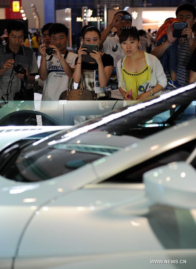 Visitors take pictures of a Maserati car at the 2013 Central China International Auto Expo in Zhengzhou, capital of central China's Henan Province, June 12, 2013. The five-day expo kicked off here on Wednesday. (Xinhua/Li Bo)