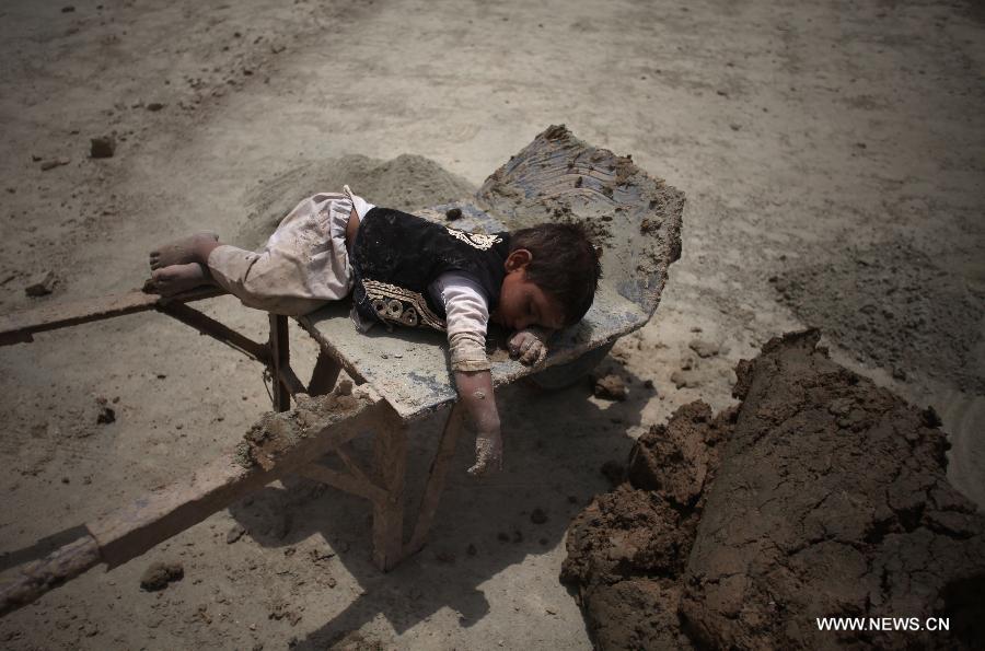 An Afghan child takes a rest on a cart at a brick factory in Kabul, Afghanistan on June 12, 2013. Afghan labor children work as usual on June 12 while many countries around the world mark the day as the World Day Against Child Labor. The International Labor Organization (ILO) launched the World Day Against Child Labor in 2002, which falls on each June 12. (Xinhua/Ahmad Massoud) 