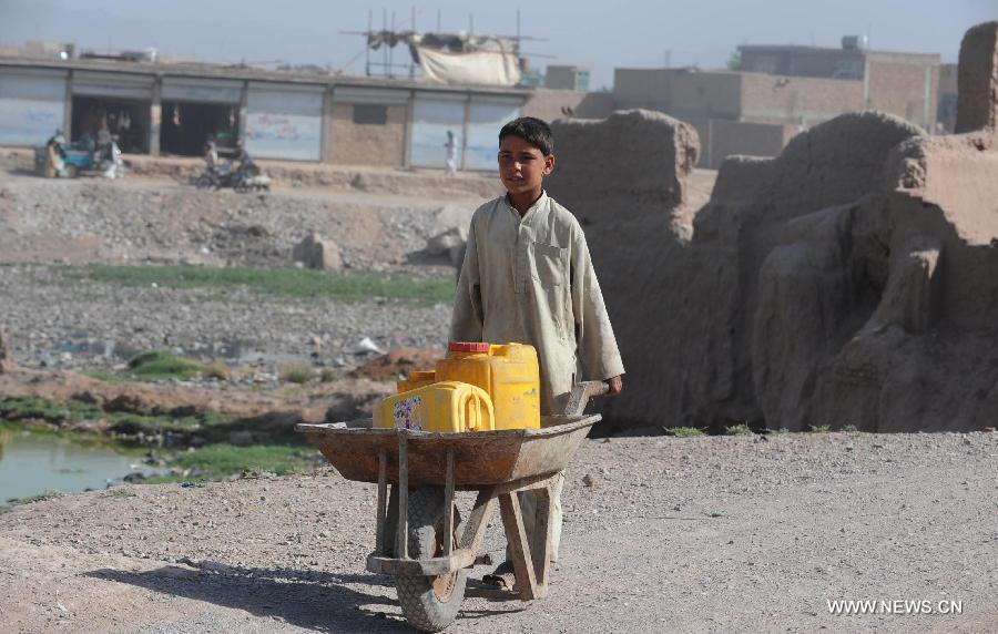 An Afghan child carries barrels of water in cart in Herat province in western of Afghanistan, on June 12, 2013. Afghan labor children work as usual on June 12 while many countries around the world mark the day as the World Day Against Child Labor. The International Labor Organization (ILO) mark the World Day Against Child Labor since 2002. (Xinhua/Sardar)