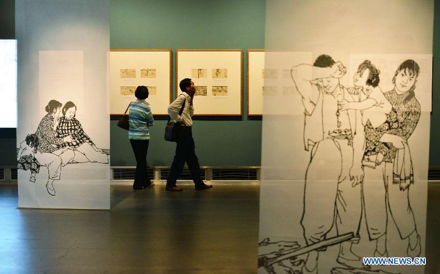 People visit an exhibition showcasing serial pictures created by He Youzhi on love stories at the Zhejiang Art Museum in Hangzhou, east China's Zhejiang Province, June 12, 2013. The exhibition kicked off here Wednesday, where the serial picture master displayed his works created since 1949. (Xinhua/Shi Jianxue) 