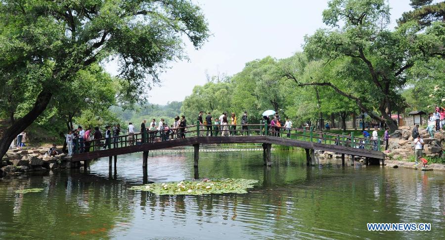 Tourists walk on a bridge in the Summer Resort in Chengde, north China's Hebei Province, June 12, 2013. As summer comes, tourist destinations in Chengde attracted many visitors during the three-day Dragon Boat Festival vacation from June 10 to June 12. Chengde is a city well known for its imperial summer resort of the Qing Dynasty (1644-1911). (Xinhua/Wang Xiao) 