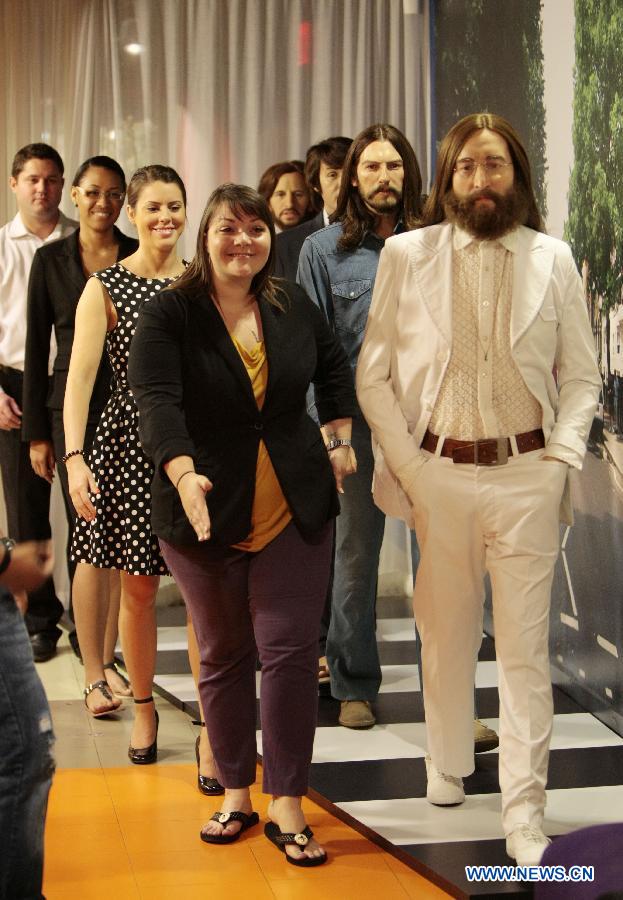 Visitors pose with the Beatles' wax figures which are exhibited to celebrate the 50th anniversary of their first LP, at Madame Tussauds in Washington D.C., capital of the United States, June 12, 2013. (Xinhua/Fang Zhe) 