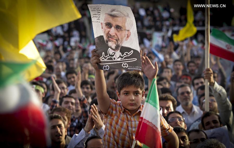 A boy raises a poster of Iran's chief nuclear negotiator and presidential candidate Saeed Jalili in his campaign rally in downtown Tehran, Iran, on June 12, 2013. Iran's 11th presidential election is scheduled for June 14. (Xinhua/Ahmad Halabisaz)