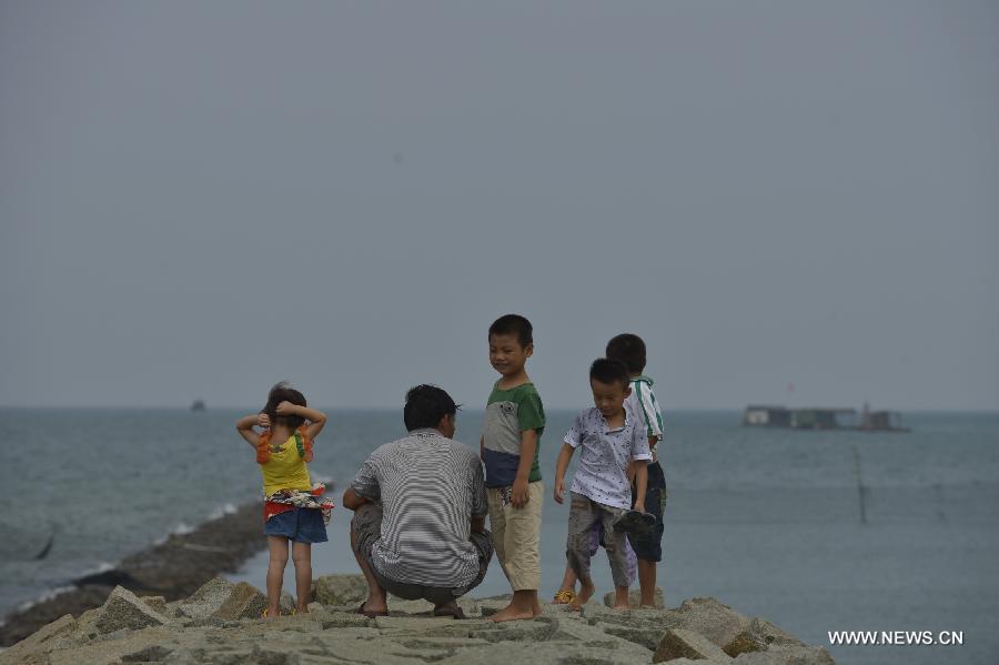 Children watch the sea at the Tanmen port in Tanmen Town, Qionghai City, south China's Hainan Province, June 12, 2013. (Xinhua/Pan Chaoyue) 