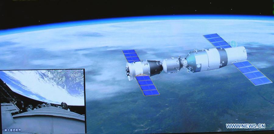 Photo taken on June 13, 2013 shows the screen at the Beijing Aerospace Control Center showing the Shenzhou-10 manned spacecraft conducting an automated docking with the orbiting Tiangong-1 space module and the view outside the propelling module of the Shenzhou-10 manned spacecraft (L, down). China's Shenzhou-10 manned spacecraft successfully completed an automated docking with the orbiting Tiangong-1 space module at 1:18 p.m. Thursday.(Xinhua/Wang Yongzhuo)