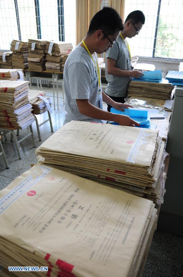 College entrance exam paper marking staff arrange paper at a paper marking room in the Northwest Normal University in Lanzhou, capital of northwest China's Gansu Province, June 13, 2013. In total 2,150 paper marking staff members need to mark the exam papers of 283,424 participants of 2013 college entrance exam in Gansu from June 10 to June 22. (Xinhua/Fan Peikun)