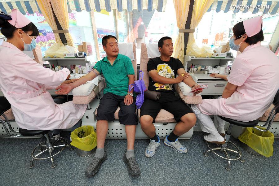 Two men donate their blood for free in a voluntary blood donation house in Yinchuan, capital of Ningxia Hui Autonomous Region, June 14, 2013. June 14 is the World Blood Donor Day. Many citizens in Yinchuan donated their blood for free on the streets of Yinchuan on Friday. (Xinhua/Peng Zhaozhi) 
