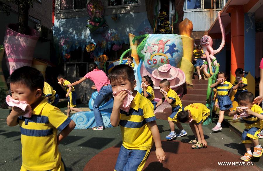 Children take part in a emergent evacuation drill in a kindergarten in Huaiyin District of Jinan, capital of east China's Shandong Province, June 14, 2013. Kindergartens in Huaiyin District held emergent fire fighting drills on Friday, in an aim to improve children and staff's ability to prevent fires, save themselves and cooperate with others. (Xinhua/Zhu Zheng) 