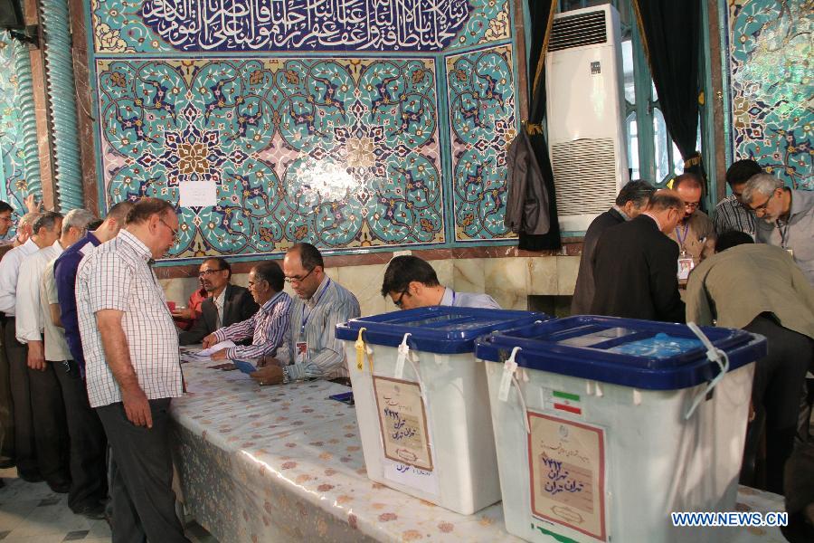 People stand in line to get their ballots at a polling station in Tehran, Iran, June 14, 2013. Iran's Supreme Leader Ayatollah Ali Khamenei cast his vote in the country's presidential election early Friday morning and opened the poll. (Xinhua/He Guanghai)