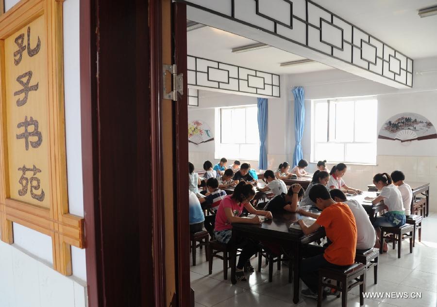 Students learn Chinese classics at Shuangqiao Primary School in Pingquan County, north China's Hebei Province, June 14, 2013. Learning Chinese classics, like the Three-Character Classic and the Analects of Confucius, for one class hour per week has been part of the curriculum for students in Shuangqiao Primary School since 2009. (Xinhua/Wang Xiao)