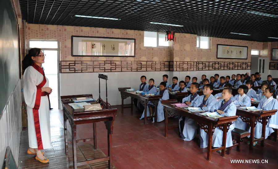 Students have a Chinese classics class at Shuangqiao Primary School in Pingquan County, north China's Hebei Province, June 14, 2013. Learning Chinese classics, like the Three-Character Classic and the Analects of Confucius, for one class hour per week has been part of the curriculum for students in Shuangqiao Primary School since 2009. (Xinhua/Wang Xiao)
