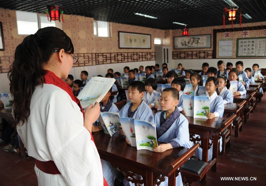 Students learn Chinese classics at Shuangqiao Primary School in Pingquan County, north China's Hebei Province, June 14, 2013. Learning Chinese classics, like the Three-Character Classic and the Analects of Confucius, for one class hour per week has been part of the curriculum for students in Shuangqiao Primary School since 2009. (Xinhua/Wang Xiao)