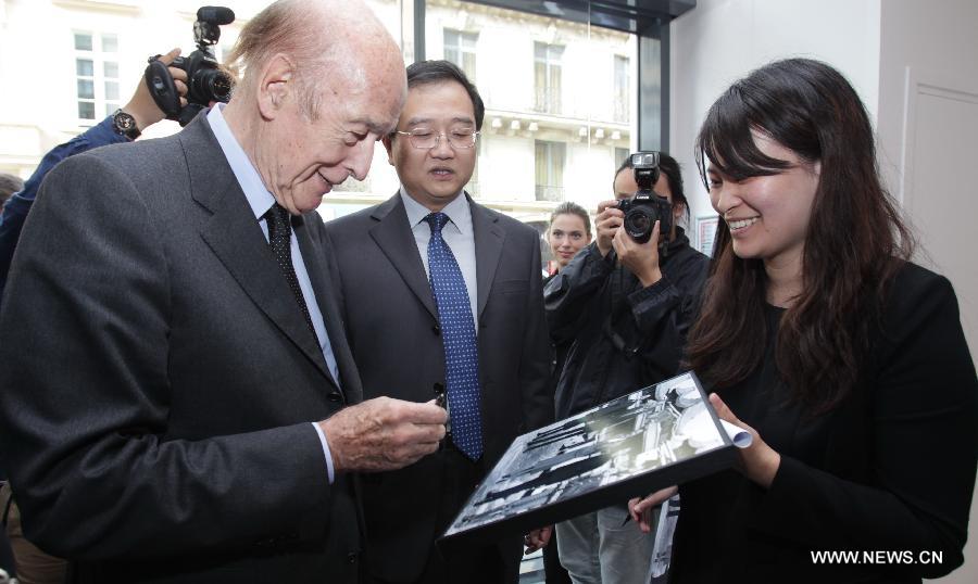 Former French president Valery Giscard d'Estaing (L) signs a picture of himself presented at a photo exhibition on China-France relationship at Xinhua Gallery in Paris, France, June 13, 2013. The photo exhibition opened here on Thursday, to mark the 50th anniversary of the establishment of diplomatic relations between China and France in 2014. (Xinhua/Gao Jing) 