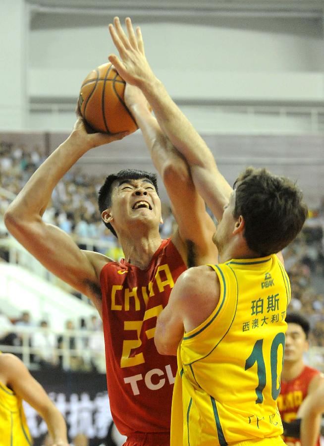 China's Li Muhao (L) is defended by Australia's Cameron Gliddon during the 2013 Sino-Australian Men's International Basketball Challenge in Yongcheng, central China's Henan Provice, June 14, 2013. China won the match 88-81. (Xinhua/Wang Song)
