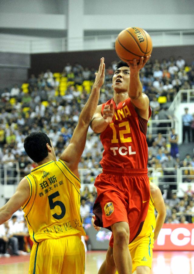 China's Zhang Bo (R) is defended by Australia's Jason Cadee during the 2013 Sino-Australian Men's International Basketball Challenge in Yongcheng, central China's Henan Provice, June 14, 2013. China won the match 88-81. (Xinhua/Wang Song)