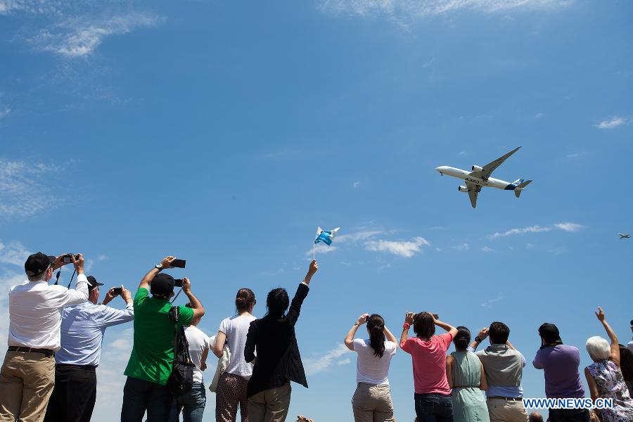 Spectators wave to Airbus's A350 XWB (eXtra Wide Body) plane before its landing at the Toulouse-Blagnac airport, southwestern France, on June 14, 2013. After its first four-hour test flight, the A350 XWB plane landed safely in southern France on Friday. (Xinhua/Chen Cheng)