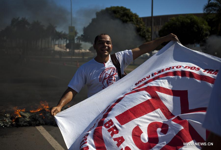 A man holds a banner during a protest in front of the Mane Garrincha National Stadium, in Brasilia, Brazil, on June 14, 2013. The 2013 FIFA Confederations Cup will be held from June 15 to 30, 2013. (Xinhua/Guillermo Arias)