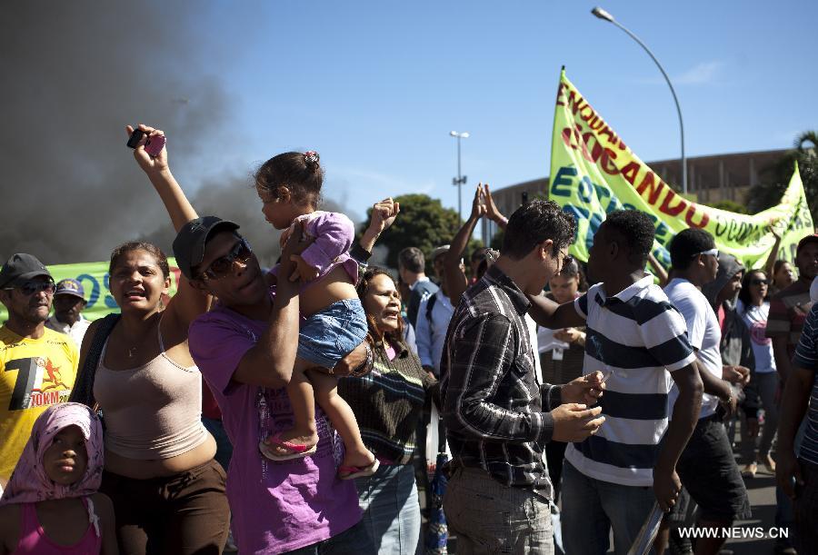 Residents attend a protest in front of the Mane Garrincha National Stadium, in Brasilia, Brazil, on June 14, 2013. The 2013 FIFA Confederations Cup will be held from June 15 to 30, 2013. (Xinhua/Guillermo Arias)