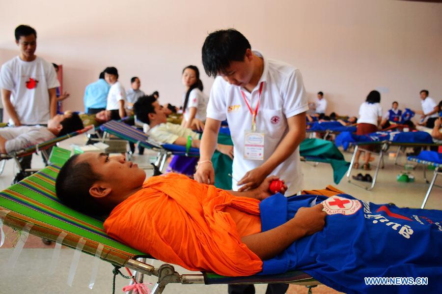 People donate blood on the occasion of the World Blood Donor Day in Vientiane, Laos, June 14, 2013. Over 1,000 local people donated blood on the 10th World Blood Donor Day. (Xinhua/Liu Ailun)