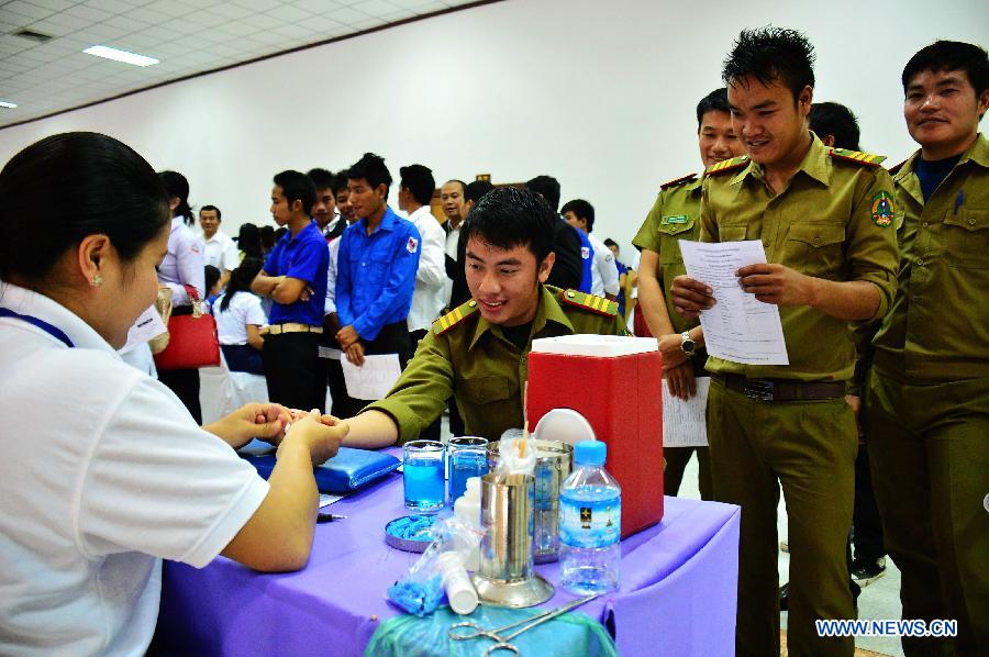 People do body check before donating blood on the occasion of the World Blood Donor Day in Vientiane, Laos, June 14, 2013. Over 1,000 local people donated blood on the 10th World Blood Donor Day. (Xinhua/Liu Ailun)