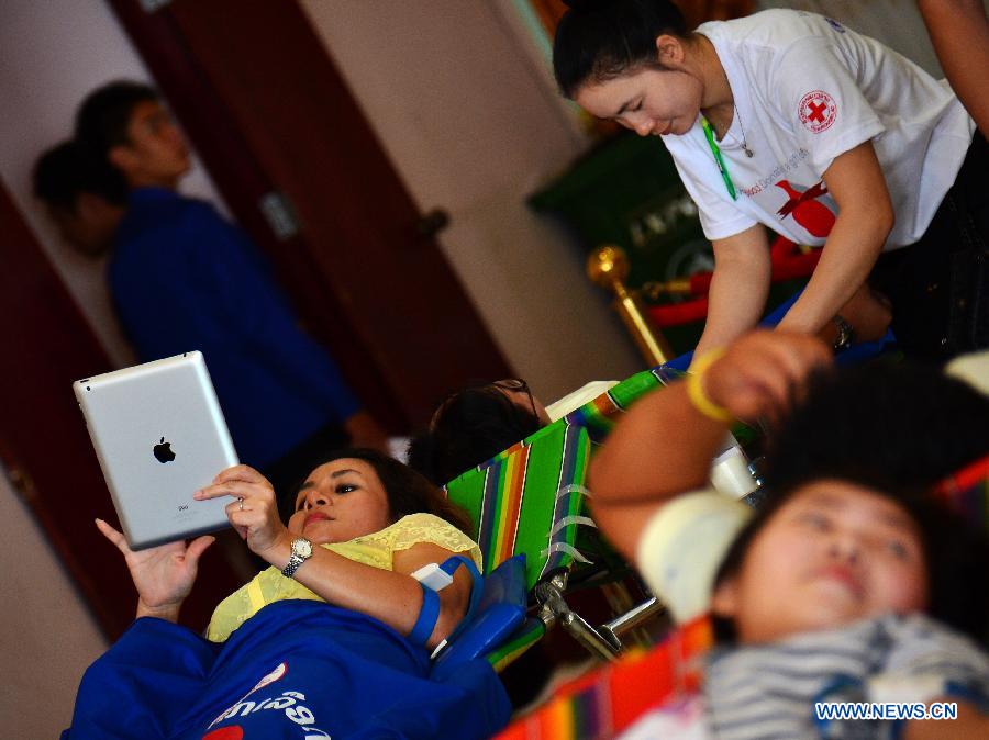 People donate blood on the occasion of the World Blood Donor Day in Vientiane, Laos, June 14, 2013. Over 1,000 local people donated blood on the 10th World Blood Donor Day. (Xinhua/Liu Ailun)
