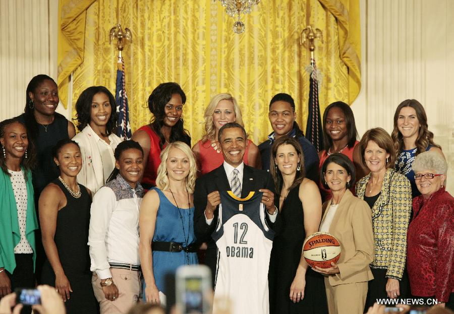 U.S. President Barack Obama (below C) poses for group photos with Indiana Fever players during the welcome ceremony of WNBA champion Indiana Fever at the White House in Washington D.C. on June 14, 2013. (Xinhua/Fang Zhe)