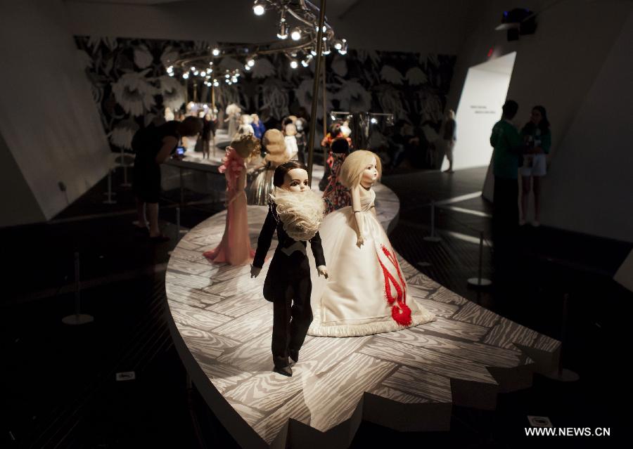 Dressed-up dolls are seen at the Viktor & Rolf Dolls exhibit, as part of the 2013 Luminato Festival, at Royal Ontario Museum in Toronto, Canada, June 14, 2013. Every aspect of each doll's look was scaled down to create exact replicas of the original creation by designers Viktor Horsting and Rolf Snoeren. (Xinhua/Zou Zheng)