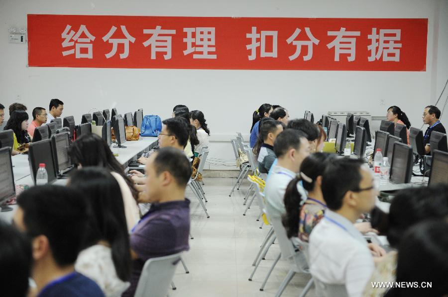 College entrance exam paper marking staff members work at a paper marking room in Guizhou Normal University in Guiyang, capital of southwest China's Guizhou Province, June 14, 2013. The paper marking work in Guizhou opens to several examinees and their parents on Friday. (Xinhua/Liu Xu)