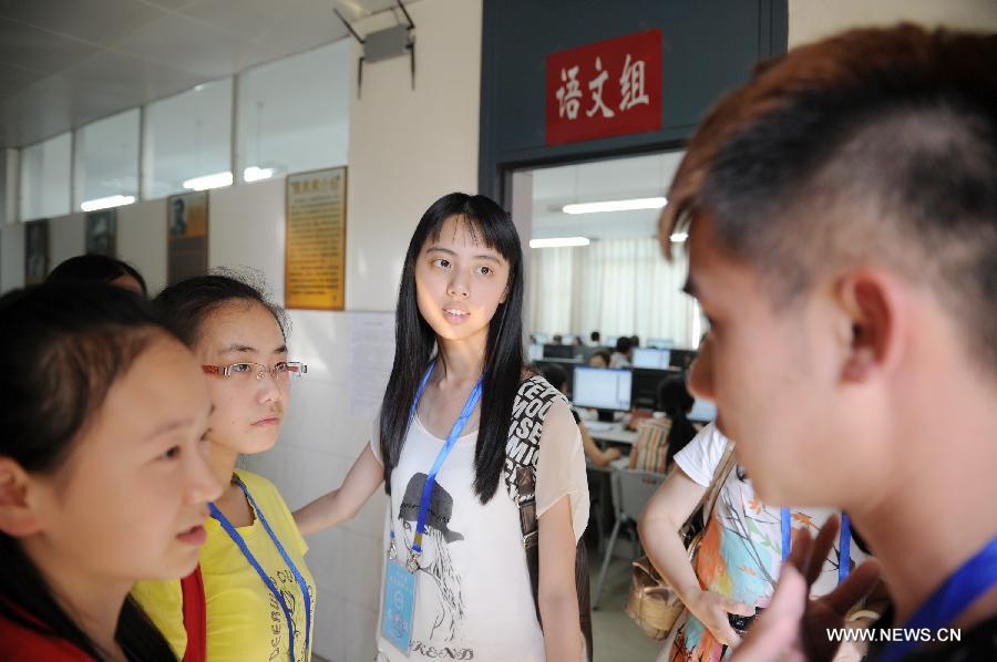 Examinees talk with each other after viewing the college entrance exam paper marking work at a paper marking room in Guizhou Normal University in Guiyang, capital of southwest China's Guizhou Province, June 14, 2013. The paper marking work in Guizhou opens to several examinees and their parents on Friday. (Xinhua/Liu Xu)