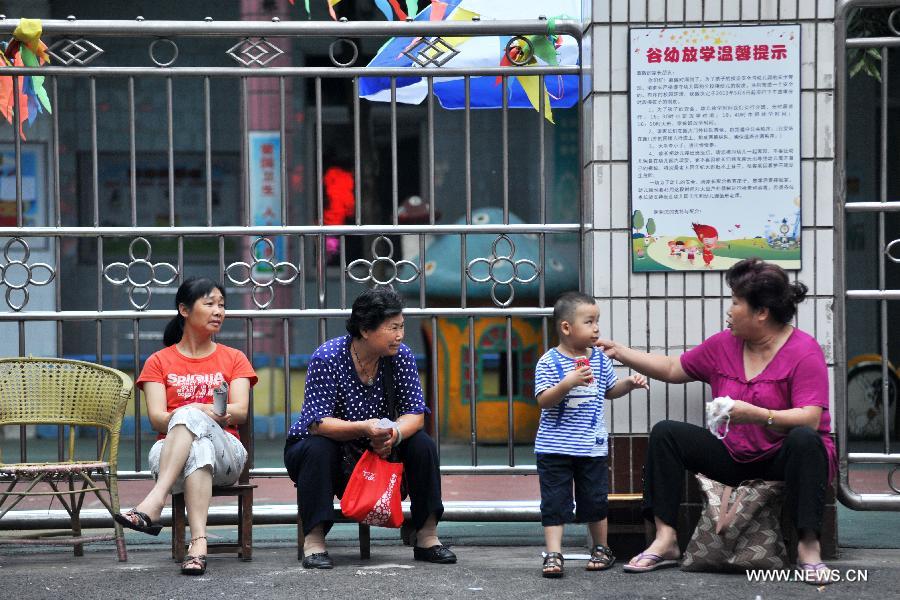 Parents queue at the gate of the Kindergarten of the Gubu Road of Liuzhou City, south China's Guangxi Zhuang Autonomous Region, June 15, 2013. Most kindergartens in Liuzhou started the registration for new students on June 15 and 16, when some parents who wanted to send their children into public kindergartens queued for the whole night for the registration. There are more than 200 kindergartens in Liuzhou City, in which only 14 are public ones. Attracted by the low costs and good reputation of the public kindergartens which often enroll limited number of students every year, some parents spare no effort in striving for the registration. Many parents even queue for the whole night for the registration, which has become a common phenomenon in many places of the country. (Xinhua/Li Bin)