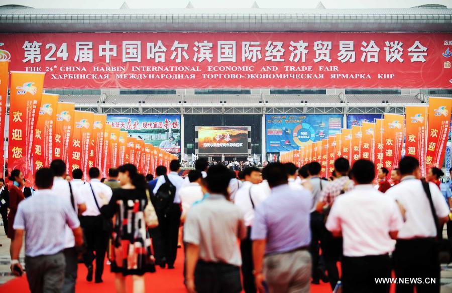 People enter the exhibition hall of the 24th China Harbin International Economic and Trade Fair in Harbin, capital of northeast China's Heilongjiang Province, June 15, 2013. A total of 9,335 exhibitors from 75 countries and regions took part in the fair. (Xinhua/Wang Jianwei)