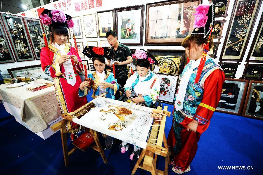 Craftswomen make embroidery works in style of the Man ethnic group at the 24th China Harbin International Economic and Trade Fair in Harbin, capital of northeast China's Heilongjiang Province, June 15, 2013. A total of 9,335 exhibitors from 75 countries and regions took part in the fair. (Xinhua/Wang Kai)