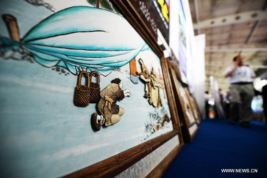 A painting with decoration of fish skin is displayed at the 24th China Harbin International Economic and Trade Fair in Harbin, capital of northeast China's Heilongjiang Province, June 15, 2013. A total of 9,335 exhibitors from 75 countries and regions took part in the fair. (Xinhua/Wang Kai)