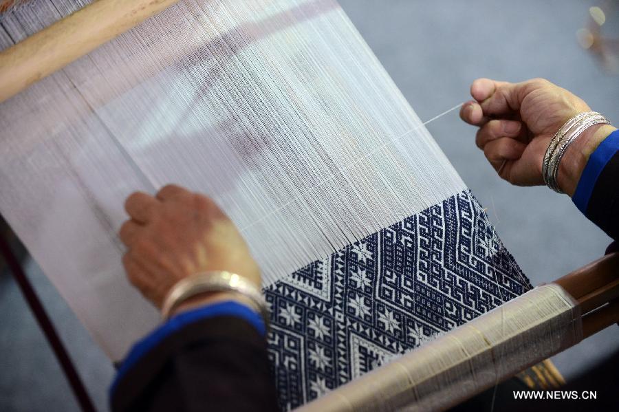 An artist makes "Dong Jin", a kind of textile of the Dong ethnic Group in China, at the 4th International Festival of Intangible Cultural Heritage in Chengdu, capital of southwest China's Sichuan Province, June 15, 2013. The nine-day festival kicked off here on Saturday. (Xinhua/Li Xiangyu)