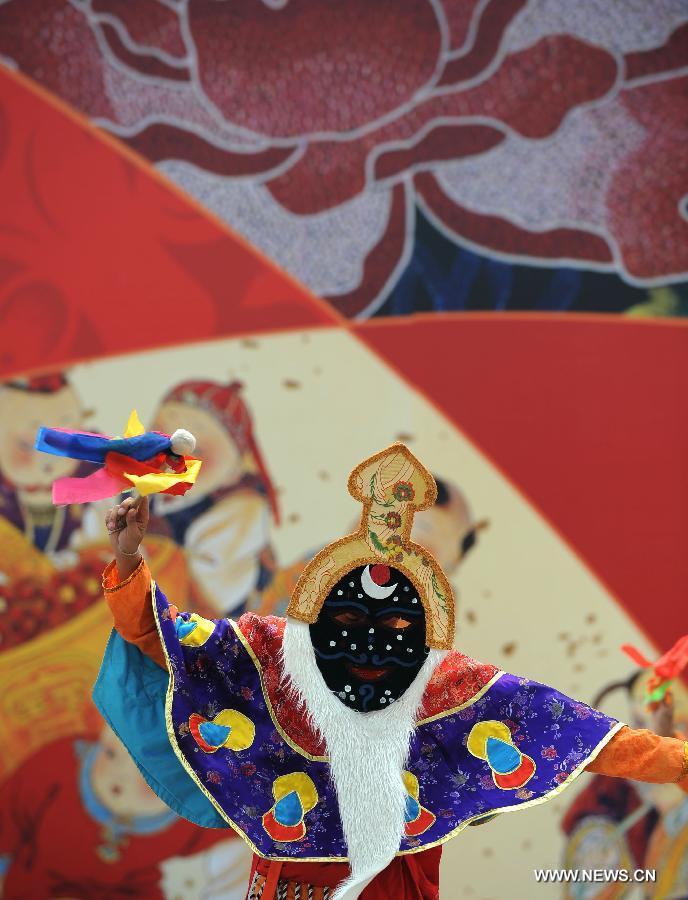 An actor gives a dance performance in style of the Tibetan ethnic group at the opening ceremony of the 4th International Festival of Intangible Cultural Heritage in Chengdu, capital of southwest China's Sichuan Province, June 15, 2013. The nine-day festival kicked off here on Saturday. (Xinhua/Xue Yubin)  
