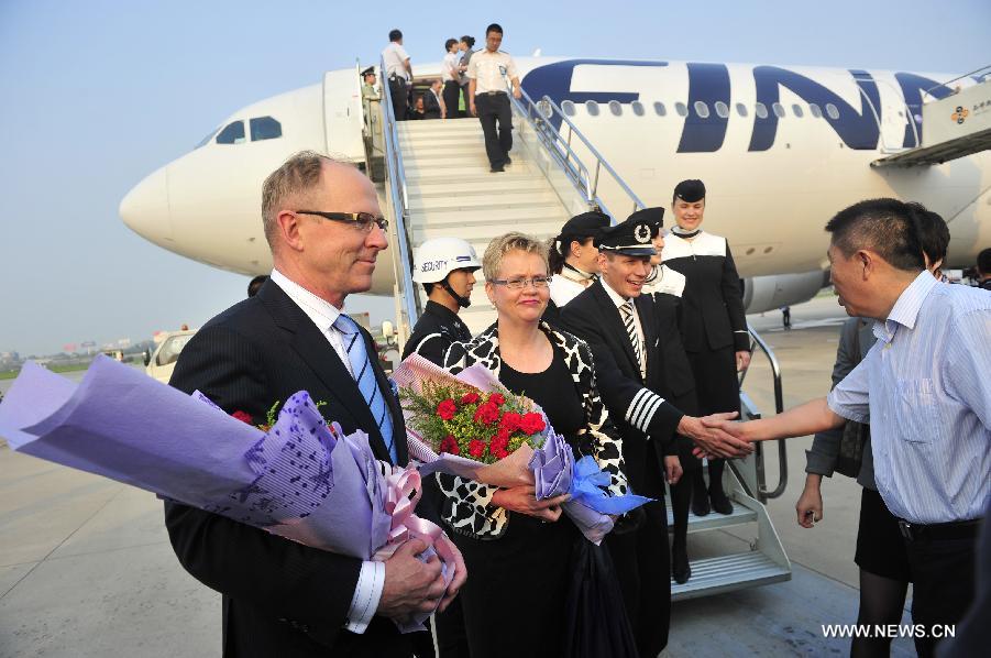 Workers of the Xianyang International Airport greet the crew members of the direct flight from Helsinki to Xi'an in Xi'an, capital of northwest China's Shaanxi Province, June 15, 2013. The first direct international airline to Europe from northwest China was opened on Saturday. Xi'an has become Finnair's fifth city in China to open direct international airlines after Beijing, Shanghai, Hong Kong and Chongqing. (Xinhua/Yuan Jingzhi)