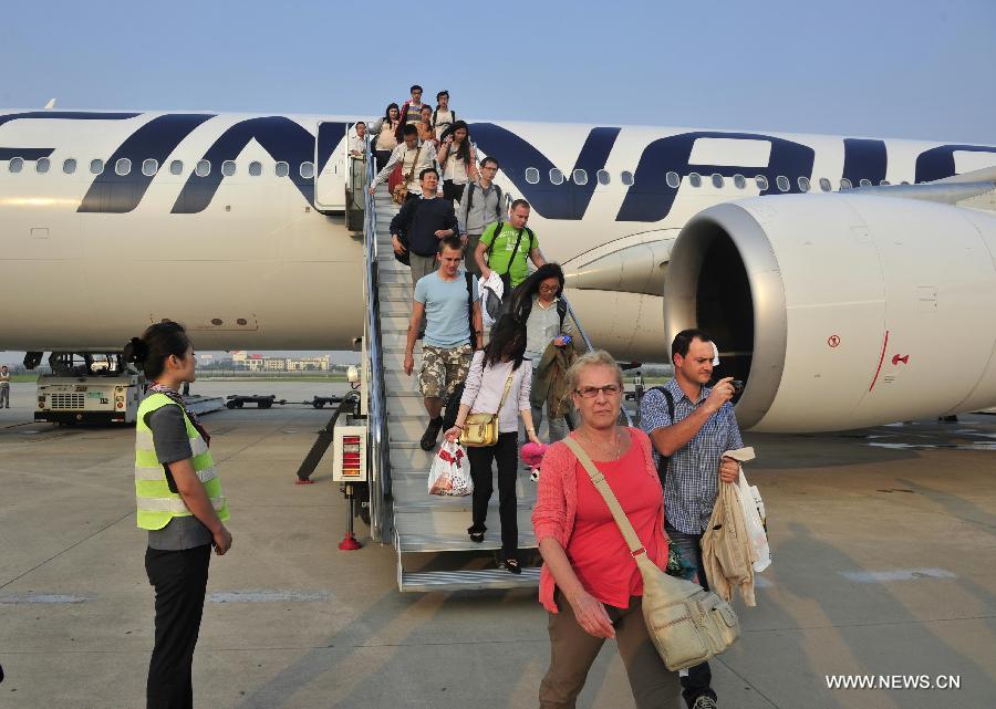 The first batch of passengers of the direct flight from Helsinki to Xi'an walk down the plane in the Xianyang International Airport in Xi'an, capital of northwest China's Shaanxi Province, June 15, 2013. The first direct international airline to Europe from northwest China was opened on Saturday. Xi'an has become Finnair's fifth city in China to open direct international airlines after Beijing, Shanghai, Hong Kong and Chongqing. (Xinhua/Yuan Jingzhi)