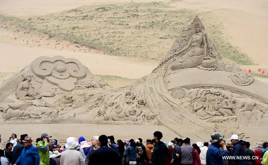 Visitors view an artwork of sand sculpture during a tourism promotion event held at the scenery spot of the Qinghai Lake in northwest China's Qinghai Province, June 15, 2013. (Xinhua/Zhang Hongxiang) 
