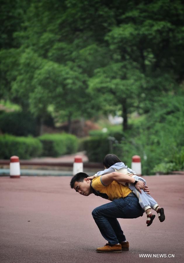 A child climbs on her father's back at a park in Changsha, capital of central China's Hunan Province, May 30, 2013. The third Sunday in June marks the Father's Day, which falls on June 16 this year. (Xinhua/Cheng Tingting)  