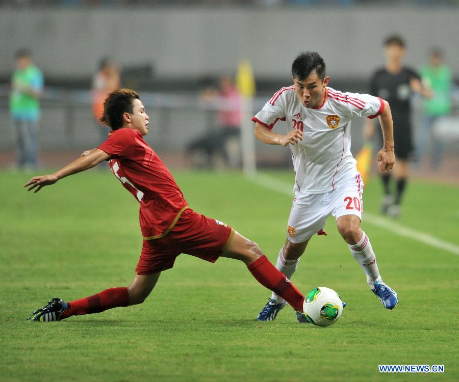 China's Yu Hanchao (R) vies with Thailand's Thitiphan Puangjan during their friendly soccer match in Hefei, east China's Anhui Province, June 15, 2013. Thailand won 5-1. (Xinhua/Guo Chen) 