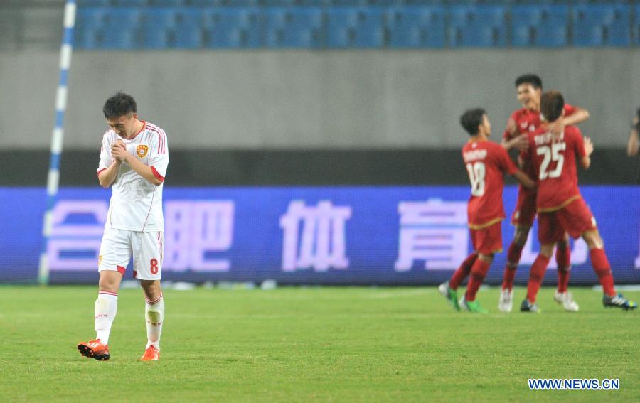 China's Wang Yongpo (1st L) reacts as Thailand's players celebrate their scoring during their friendly soccer match in Hefei, east China's Anhui Province, June 15, 2013. Thailand won 5-1. (Xinhua/Guo Chen) 