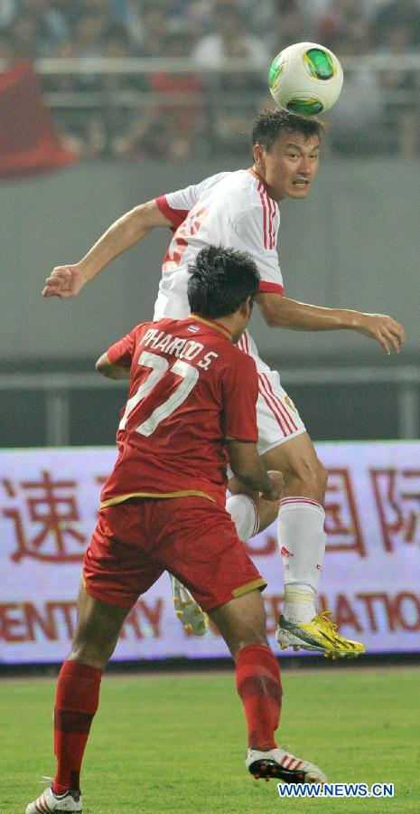 China's Gao Lin (Top) vies with Thailand's Phairod Sokham during their friendly soccer match in Hefei, east China's Anhui Province, June 15, 2013. Thailand won 5-1. (Xinhua/Guo Chen) 