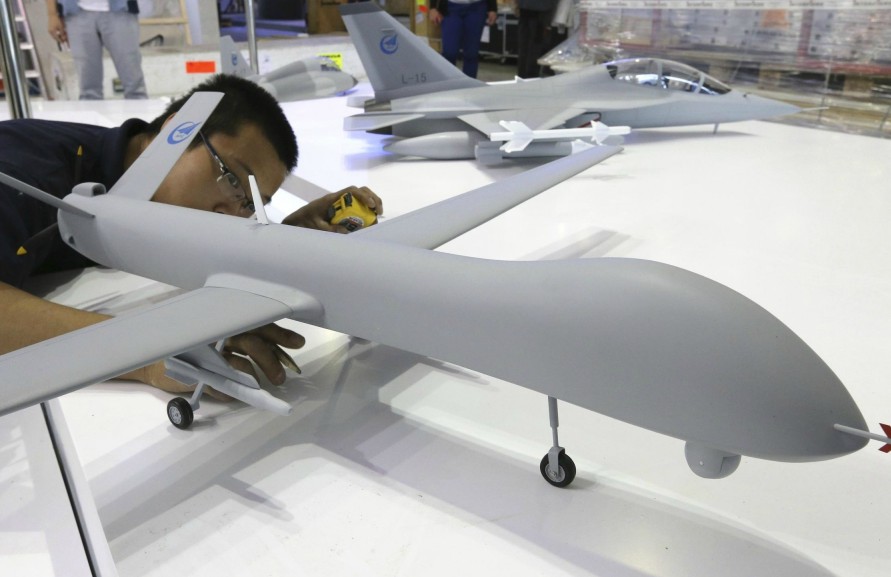 A worker finishes installing a UAV model at the Aviation Industry Corporation of China (AVIC) exhibition area, two days before the opening of the 50th Paris Air Show, at the Le Bourget airport near Paris, June 15, 2013. (Photo Source: chinadaily.com.cn) 